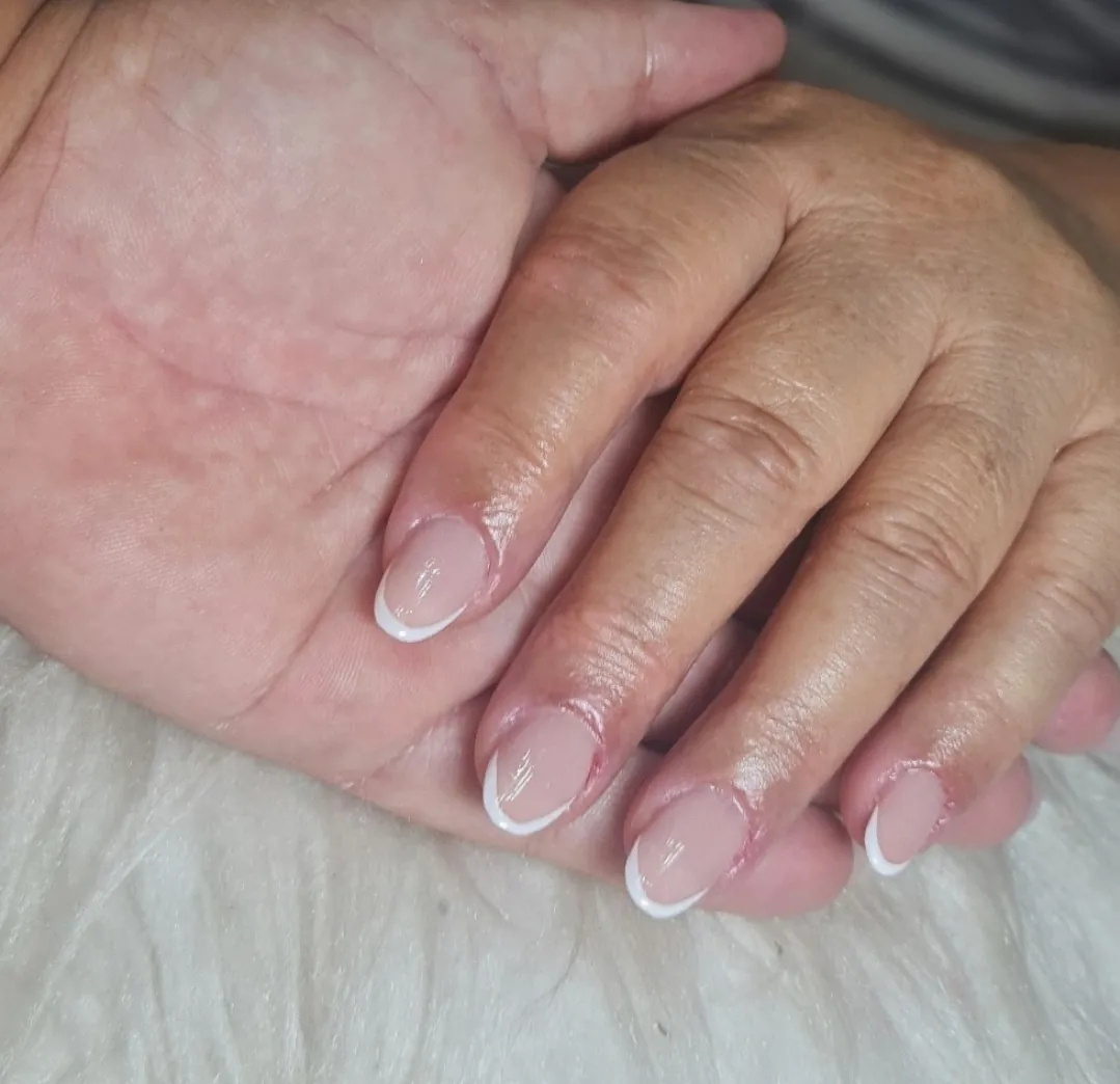 Banho de gel em unha curta visto de perto, com brilho