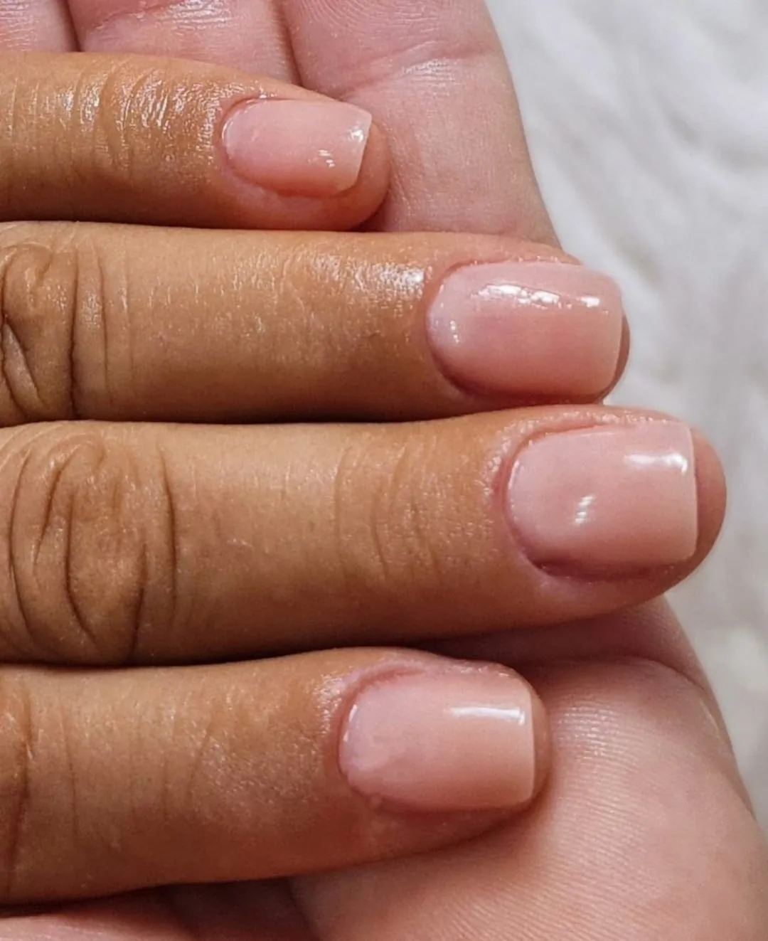 Unhas que eram roídas, recuperadas e lisas, com acabamento nude